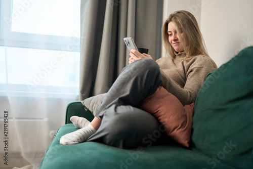 Cozy phone browsing with soft morning calm at home