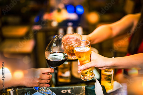 food and drink male friends are happy drinking beer and clinking glasses at a bar or pub.