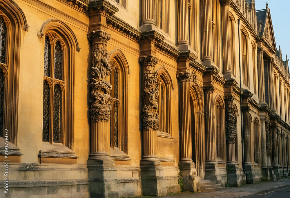 Fototapeta premium Higher education and academic excellence, historic university building with ornate stone columns and gothic architecture in golden hour sunlight