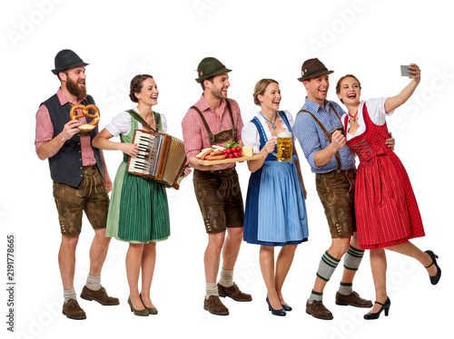Cheerful group of friends in traditional Bavarian clothing celebrating Oktoberfest isolated on white background