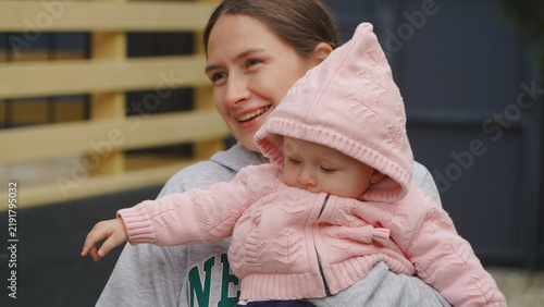 A young mother and her baby are relaxing outdoors