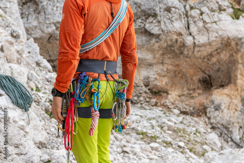 Cortina d'Ampezzo, Italy. Rock climber carrying ropes, carabiners and technical climbing equipment at Cinque Torri in the Dolomites