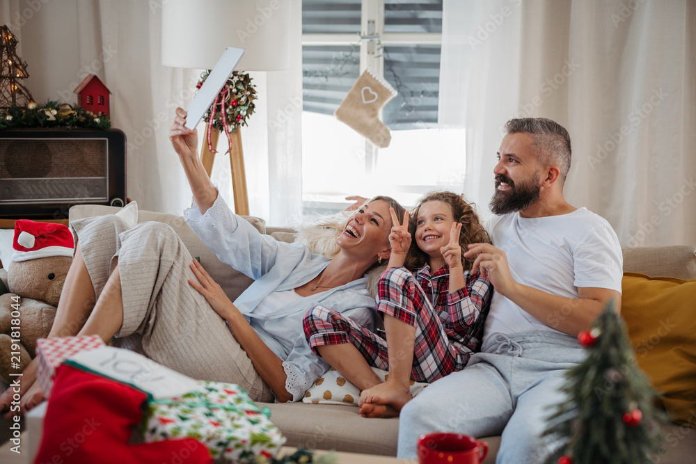 Obraz premium Family making Christmas video call with relatives during holiday celebration at home.