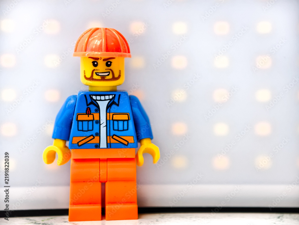Fototapeta premium Russia, St. Petersburg, August 8, 2020 A close-up of a Lego man wearing a hard hat, great for illustration or construction-themed designs