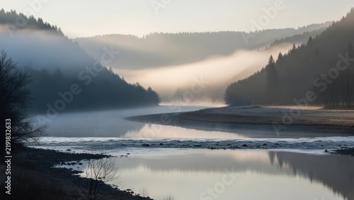 Tranquil river landscape shrouded in mist and morning light.