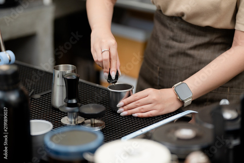 Foto Espresso preparation concept with a barista holding a coffee tamper at a cafe workstation, representing coffee, tamping, barista, brewing, espresso, precision, preparation