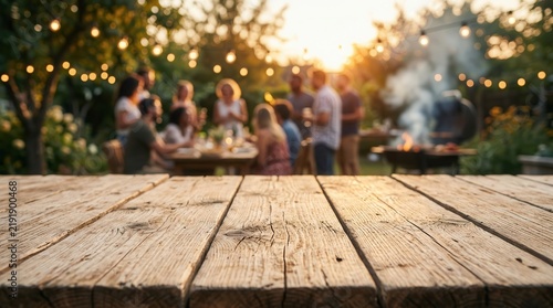 Empty wooden table for product placement with blurred friends and family at a summer barbecue.