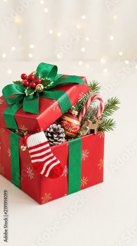 A beautifully decorated Christmas gift box overflowing with seasonal surprises perfectly wrapped in festive colors, capturing holiday cheer, cheerful, unique, generosity