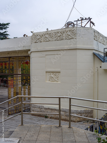 Obraz na plátně Decorative relief carvings on white architectural wall with metal gate entrance