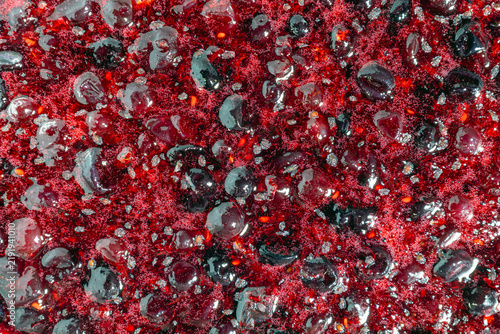 Fototapeta Blackcurrant jam thick syrup with glossy bubbles closeup texture