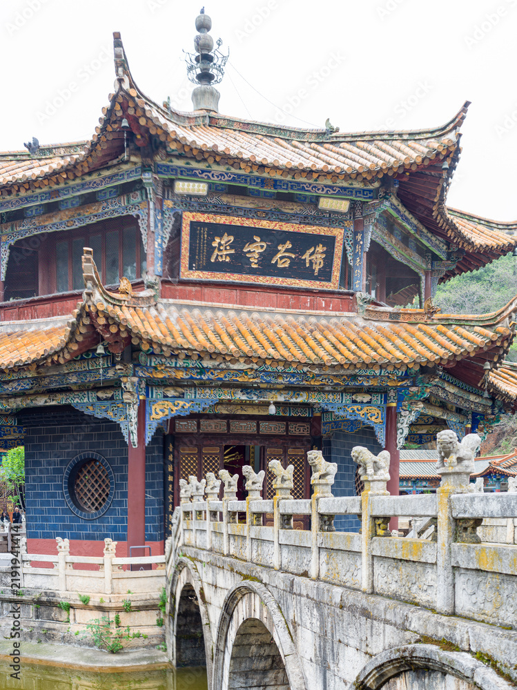 Obraz premium Front facade of decorative Chinese pavilion with stone bridge in foreground