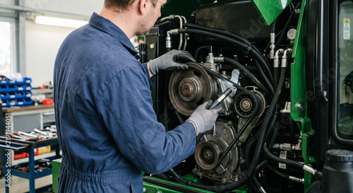 Technician Inspecting Engine Drive Belt and Pulley System
