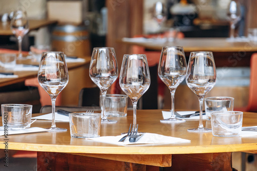 Foto Restaurant table set with empty wine glasses, water glasses, cutlery and napkins