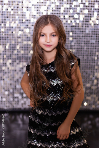 Portrait of Young Girl in Sequined Dress with Glitter Bokeh Background