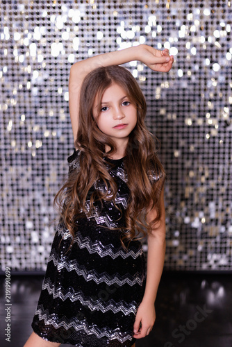 Portrait of Young Girl in Sequined Dress with Glitter Bokeh Background