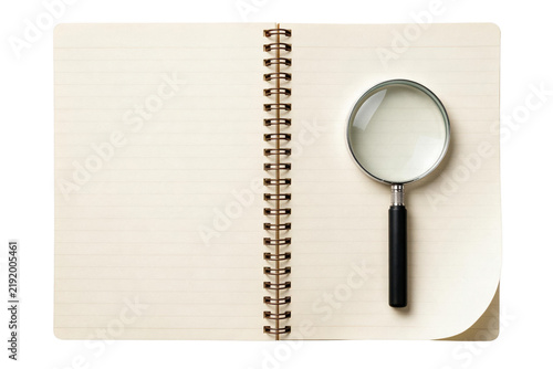 Magnifying Glass Resting on an Open Lined Spiral Notebook
