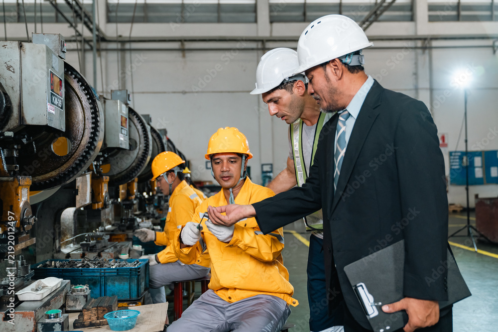 Fototapeta premium Industrial worker factory engineer inspection machinery safety helmet factory engineer inspecting machinery with industrial workers manufacturing facility, highlighting teamwork, safety