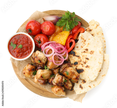 Cuadro en lienzo Delicious shish kebabs with vegetables, sauce and lavash isolated on white, top