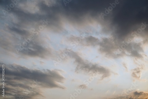 Canvastavla A dramatic view of a cloudy sky with thick layers of grey cumulus clouds at twilight
