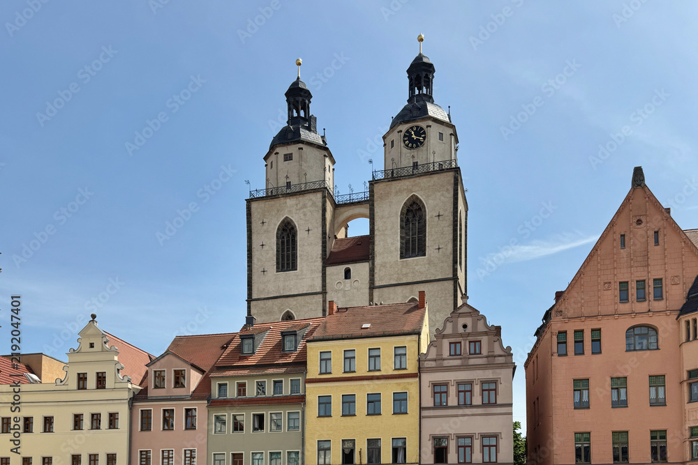 Obraz premium The twin towers of a church and the historic buildings in the old town of Wittenberg, Germany