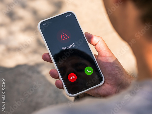 Scam call warning on smartphone alerts user to phone fraud, vishing, caller spoofing and identity theft risk, mobile cybersecurity and consumer protection.