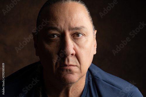 Portrait of a middle-aged Brazilian man, low-key style, selective focus.