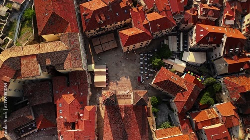 kotor, montenegro - aerial top down view of a paved old town square with market stalls, cafe awnings, colourful balloons and people walking between medieval buildings