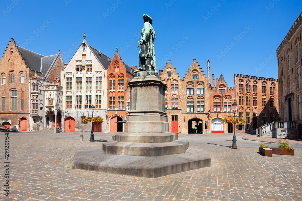 Obraz premium Jan van Eyck statue and medieval houses in Bruges, Belgium