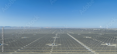 Aerial Morning View of Vast Solar Photovoltaic Power Station in Dunhuang Gobi Desert with Glowing Molten Salt Solar Thermal Tower