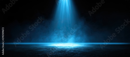 A lone blue spotlight pierces dark smoke, illuminating a textured floor