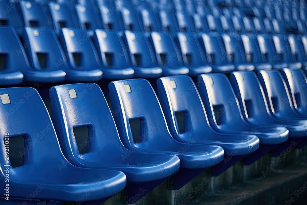 Fototapeta premium Rows of empty, bright blue stadium seats with focused lighting