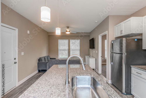 Modern kitchen with granite island countertop and sink in an open plan living area stainless sink living room kitchen interior home interior modern apartment residential design kitchen faucet