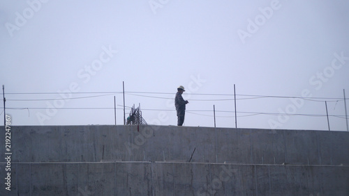 Принти на полотні Construction worker standing on top of an elevated highway concrete bridge girde