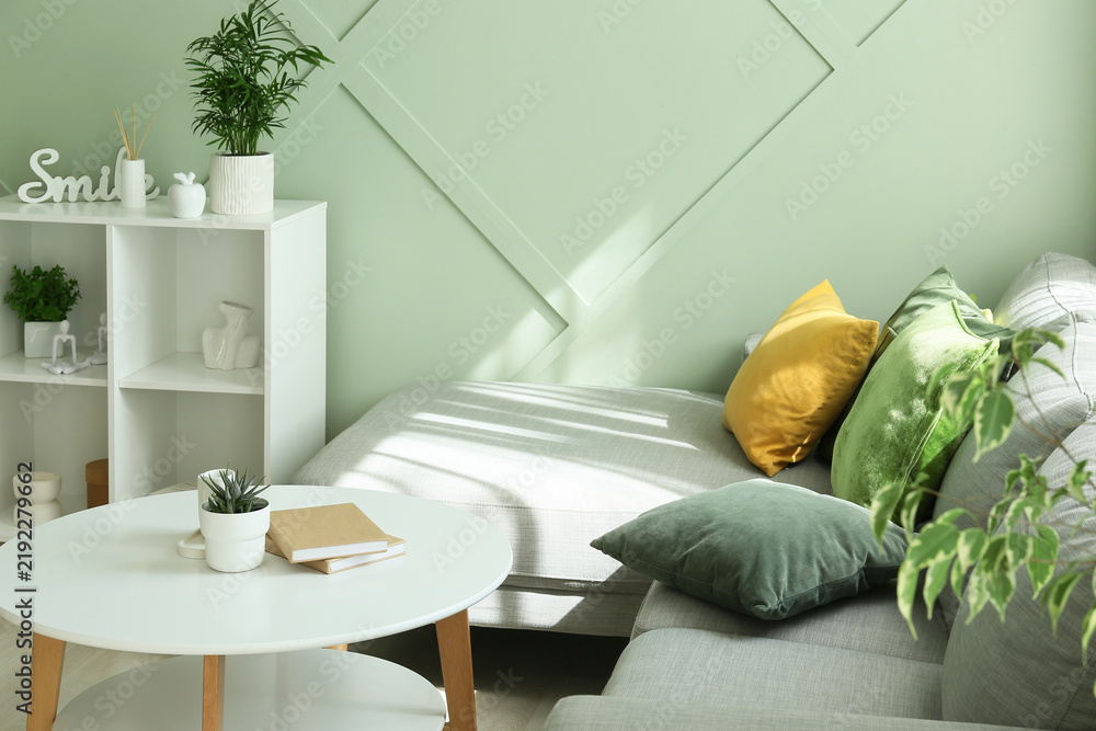 Obraz premium Interior design and home comfort, cozy living room with modern sofa and green wall decor for relaxing lifestyle and domestic well being