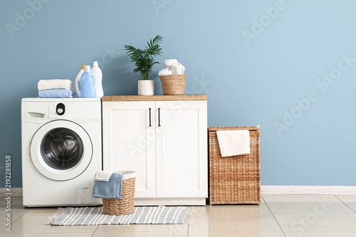 Interior of laundry room with washing machine, counter and baskets
