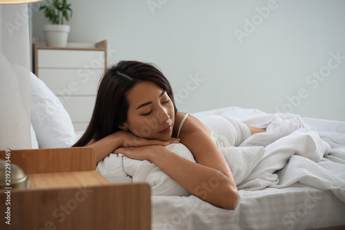 Morning of beautiful Asian woman sleeping under blanket in bedroom