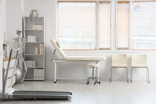 Interior of physiotherapists office with couch, chairs and human skeleton