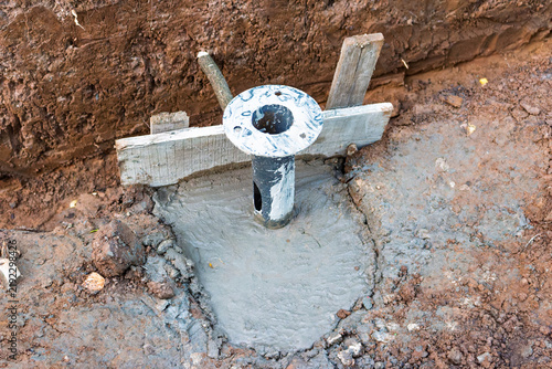 Принти на полотні Freshly poured concrete foundation for a park light pole with wooden formwork in