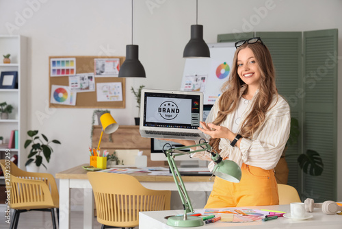 Female web designer with laptop in office