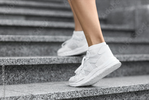 Sporty young woman jogging on stairs in park  closeup