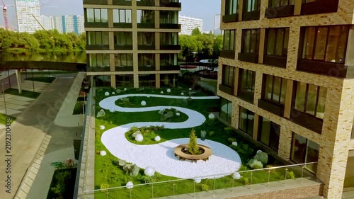 Modern luxury residential complex rooftop park with landscaped garden and winding white gravel paths