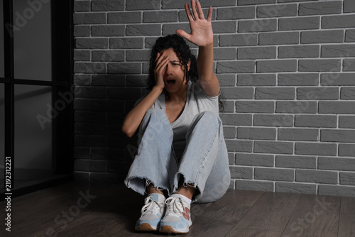 Young African-American woman having panic attack in room