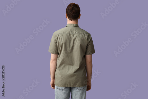 Young man in stylish green collar shirt on lilac background, back view