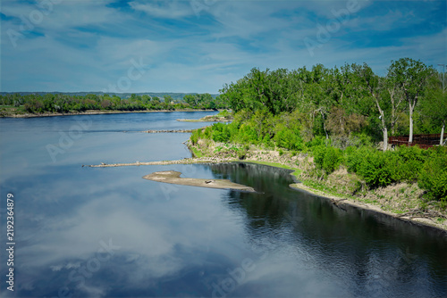 THE MISSOURI RIVER RUNNING THROUGH OMAHA NEBRASKA WITH CALM WATER AND A NICE REFLECTION IN THE WATER