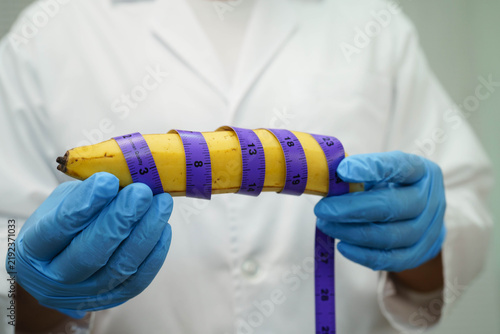 Konstfotografi Doctor holding a banana with measuring tape, penis health.