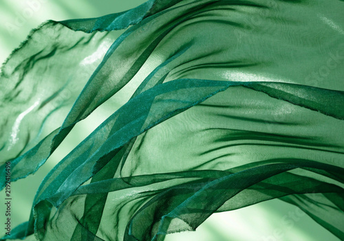 Flowing Green Chiffon Fabric Swirls on Light Green Background