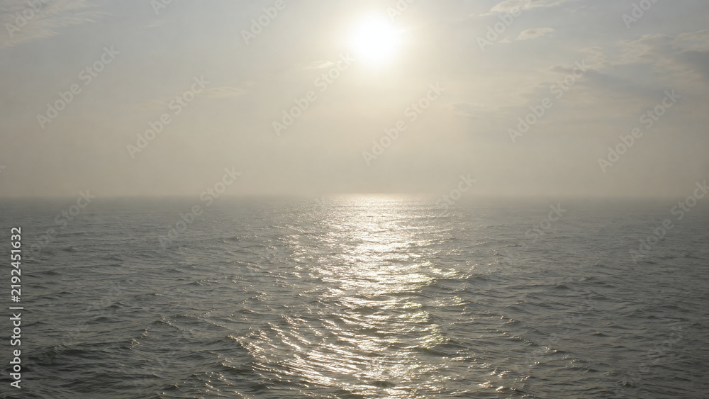 Fototapeta premium Hazy Sunlight Shimmering Across the Open Sea