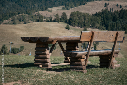 Foto Wooden table with a bench on a hill, view of the mountains