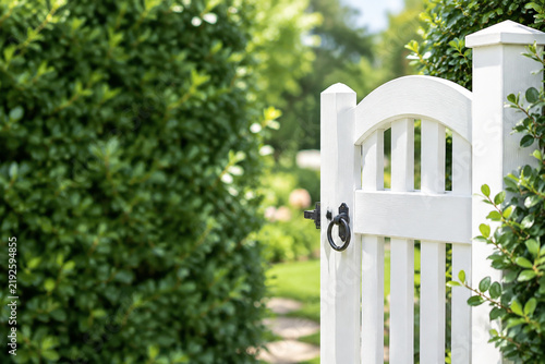 White painted garden gate with green hedge, inviting outdoor entrance concept