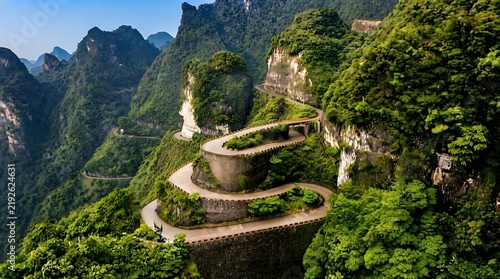 Curving mountain road winds through lush green forest with scenic cliffside views for travel marketing or Dramatic winding road through dense forest and rocky cliffs, ideal for tourism and automotive.